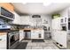 Modern kitchen equipped with stainless steel appliances, tile backsplash, and white cabinets at 405 Box Elder Way, Henderson, NV 89015