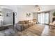 Bright living room featuring a large gray sectional, tile flooring, and sliding glass doors to the patio at 405 Box Elder Way, Henderson, NV 89015