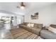 Spacious living room with gray sectional, neutral decor, and open access to the kitchen at 405 Box Elder Way, Henderson, NV 89015
