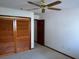Bedroom featuring a ceiling fan, neutral carpet, light wall color and closet at 5401 Painted Sunrise Dr, Las Vegas, NV 89149