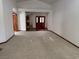 Spacious living room featuring neutral carpet, light walls, and double-door entry at 5401 Painted Sunrise Dr, Las Vegas, NV 89149