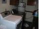 Washer and dryer sit beneath wood cabinetry and a water heater at 6325 Burgundy Way, Las Vegas, NV 89107
