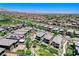 Aerial view showcases a modern planned community with green spaces and manicured lawns under a clear sky at 689 Rogue Wave St, Las Vegas, NV 89138