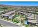 Community aerial view featuring homes, a park, and a pool, highlighting neighborhood amenities under the bright sun at 689 Rogue Wave St, Las Vegas, NV 89138