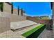 Landscaped backyard with retaining wall, artificial turf, desert landscaping, and gravel at 689 Rogue Wave St, Las Vegas, NV 89138