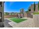 Well-manicured backyard featuring artificial turf, paver stones, and a pergola with outdoor seating at 689 Rogue Wave St, Las Vegas, NV 89138