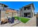 Landscaped backyard with artificial turf, stone pavers, and a covered pergola, perfect for entertaining at 689 Rogue Wave St, Las Vegas, NV 89138