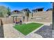 Professionally landscaped backyard featuring a pergola with swing and chairs, artificial turf, and stone pavers at 689 Rogue Wave St, Las Vegas, NV 89138
