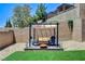 Private backyard featuring manicured lawn, patio with pergola, and lush landscaping at 689 Rogue Wave St, Las Vegas, NV 89138