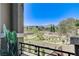 Balcony view overlooking green space, rock feature and community, with a decorative brick wall and foliage foreground at 689 Rogue Wave St, Las Vegas, NV 89138