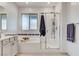 Well-lit bathroom features a bathtub with shower, patterned tile backsplash, and a large window at 689 Rogue Wave St, Las Vegas, NV 89138