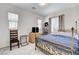 Bright bedroom with a wrought iron bed frame, two windows, and neutral decor at 689 Rogue Wave St, Las Vegas, NV 89138