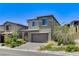 Contemporary two-story home with a two-car garage, desert landscaping, and a paved driveway at 689 Rogue Wave St, Las Vegas, NV 89138