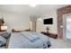 This main bedroom is complete with accent brick wall, outdoor access and flatscreen TV at 689 Rogue Wave St, Las Vegas, NV 89138