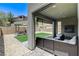 Covered patio with stylish seating and a tranquil view of the manicured backyard with lush landscaping at 689 Rogue Wave St, Las Vegas, NV 89138