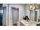 Bright bathroom features a vanity with a mirror and lights, and a shower with a patterned curtain at 7329 Restful Springs Ct, Las Vegas, NV 89128