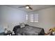 Cozy bedroom features a ceiling fan, window with blinds, and a comfortable bed with a plush gray blanket at 7329 Restful Springs Ct, Las Vegas, NV 89128