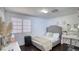 Cozy bedroom featuring a stylish bed, dark wood floors, and natural light from the window at 7329 Restful Springs Ct, Las Vegas, NV 89128