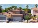 Charming two-story home with a well-maintained lawn, mature trees, and attached two-car garage at 7329 Restful Springs Ct, Las Vegas, NV 89128