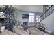 Comfortable living room with fireplace, large windows, cozy seating, and a staircase at 7329 Restful Springs Ct, Las Vegas, NV 89128