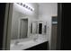 Bathroom featuring a double sink vanity with a large mirror and updated fixtures at 9065 Mastodon Ave, Las Vegas, NV 89149