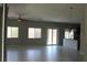 Spacious living room with tile floors, ceiling fan, and sliding glass door to the backyard at 9065 Mastodon Ave, Las Vegas, NV 89149