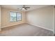 Bright bedroom featuring a ceiling fan, large window and neutral carpeting at 9626 Grapeland Ave, Las Vegas, NV 89148