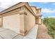 Exterior view of the two-car garage with a long driveway and desert-friendly landscaping at 9626 Grapeland Ave, Las Vegas, NV 89148