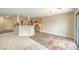 An open-concept living area featuring carpet and tile flooring with bar top and tan walls at 9626 Grapeland Ave, Las Vegas, NV 89148