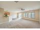 Open-concept living room featuring a ceiling fan, natural light, neutral walls, and an adjacent kitchen at 9626 Grapeland Ave, Las Vegas, NV 89148