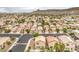 Wide aerial shot of a community with tan stucco homes, paved streets, and mountain views in the background at 9626 Grapeland Ave, Las Vegas, NV 89148