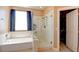 Bathroom with separate tub and glass shower, as well as a window with natural light at 98 Milicity Rd, Henderson, NV 89012