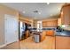 This open kitchen features stainless appliances, granite countertops, a kitchen island and wood cabinets at 98 Milicity Rd, Henderson, NV 89012