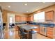 This open kitchen features stainless appliances, granite countertops, a kitchen island, and wood cabinets at 98 Milicity Rd, Henderson, NV 89012