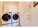 Convenient laundry room with modern side-by-side washer and dryer units and overhead cabinets for storage at 98 Milicity Rd, Henderson, NV 89012