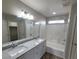 Bathroom featuring double sinks, a tub, shower, and updated fixtures at 10449 Forked Run St, Las Vegas, NV 89178