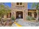 Attractive building exterior with stonework, arched entrance, and desert landscaping at 10449 Forked Run St, Las Vegas, NV 89178