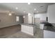 Open-concept kitchen with granite island, white cabinets, stainless appliances, and modern lighting fixtures at 10449 Forked Run St, Las Vegas, NV 89178
