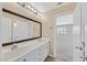 Bright bathroom with a double sink vanity, a large mirror, and a doorway leading into the bedroom at 1557 Sabatini Dr, Henderson, NV 89052