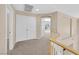 Hallway with neutral carpet and white trim and doors leading to bedrooms and stairs at 1557 Sabatini Dr, Henderson, NV 89052