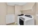 Efficient laundry room with front loading washer and dryer, storage cabinets and plenty of shelving at 1557 Sabatini Dr, Henderson, NV 89052