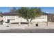 Beige single story home features a tree and security bars over the windows at 1936 Lawry Ave, North Las Vegas, NV 89032