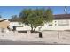 Beige single story home features a tree and security bars over the windows at 1936 Lawry Ave, North Las Vegas, NV 89032