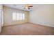 Spacious bedroom features neutral carpet, ceiling fan, and bright shuttered windows at 2131 Sandstone Cliffs Dr, Henderson, NV 89044