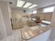 Well-equipped kitchen features light wood cabinets, granite countertops, an island bar, and ceramic tile flooring at 2524 Banora Point Dr, Las Vegas, NV 89134
