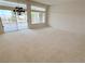 Bright living room featuring a cozy carpet, sliding glass doors and an elegant chandelier, creating a welcoming atmosphere at 2524 Banora Point Dr, Las Vegas, NV 89134