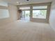 Spacious living room with lots of natural light, neutral carpet, a chandelier and sliding glass doors to the backyard at 2524 Banora Point Dr, Las Vegas, NV 89134