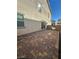 An expansive brick-paved patio extends from a beige house, perfect for outdoor living and entertainment at 2713 Abrantes Pl, Henderson, NV 89044