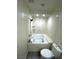 Bathroom with toilet, tub and shower combo with white marble walls and small shelves at 2784 Belcastro St, Las Vegas, NV 89117