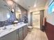 Charming bathroom featuring double sinks, decorative wallpaper, and a tiled shower at 302 Bay Village Pl, Henderson, NV 89011